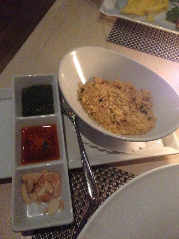 Yellow couscous, green cilantro sauce, red harissa, and fresh almond slivers